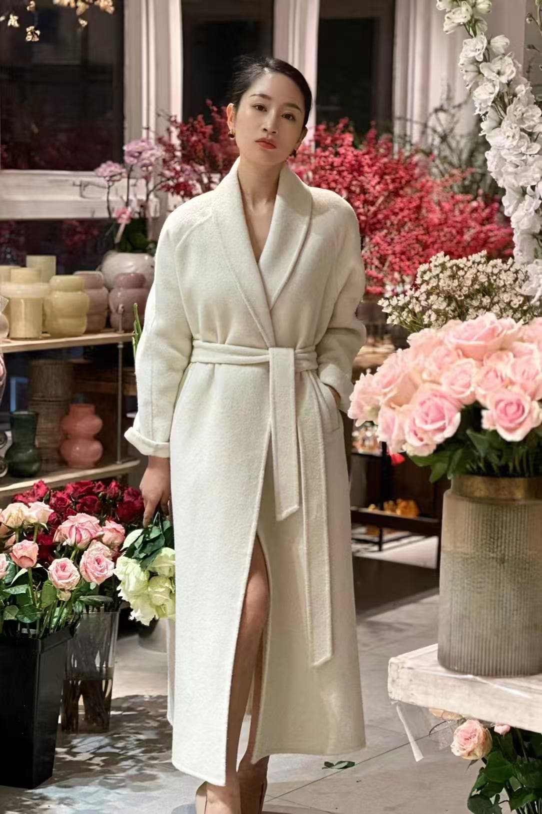 Ivory wrap cashmere coat in a floral studio setting